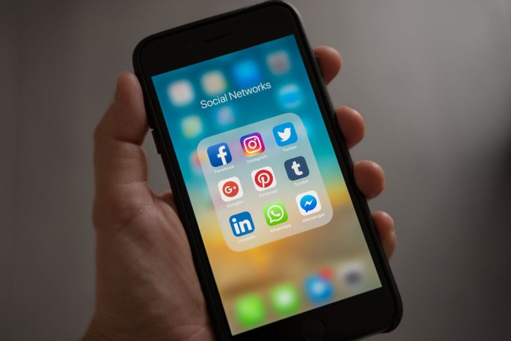 Pessoa utilizando smartphone para atendimento e gestão de redes sociais da Agência Alagoas